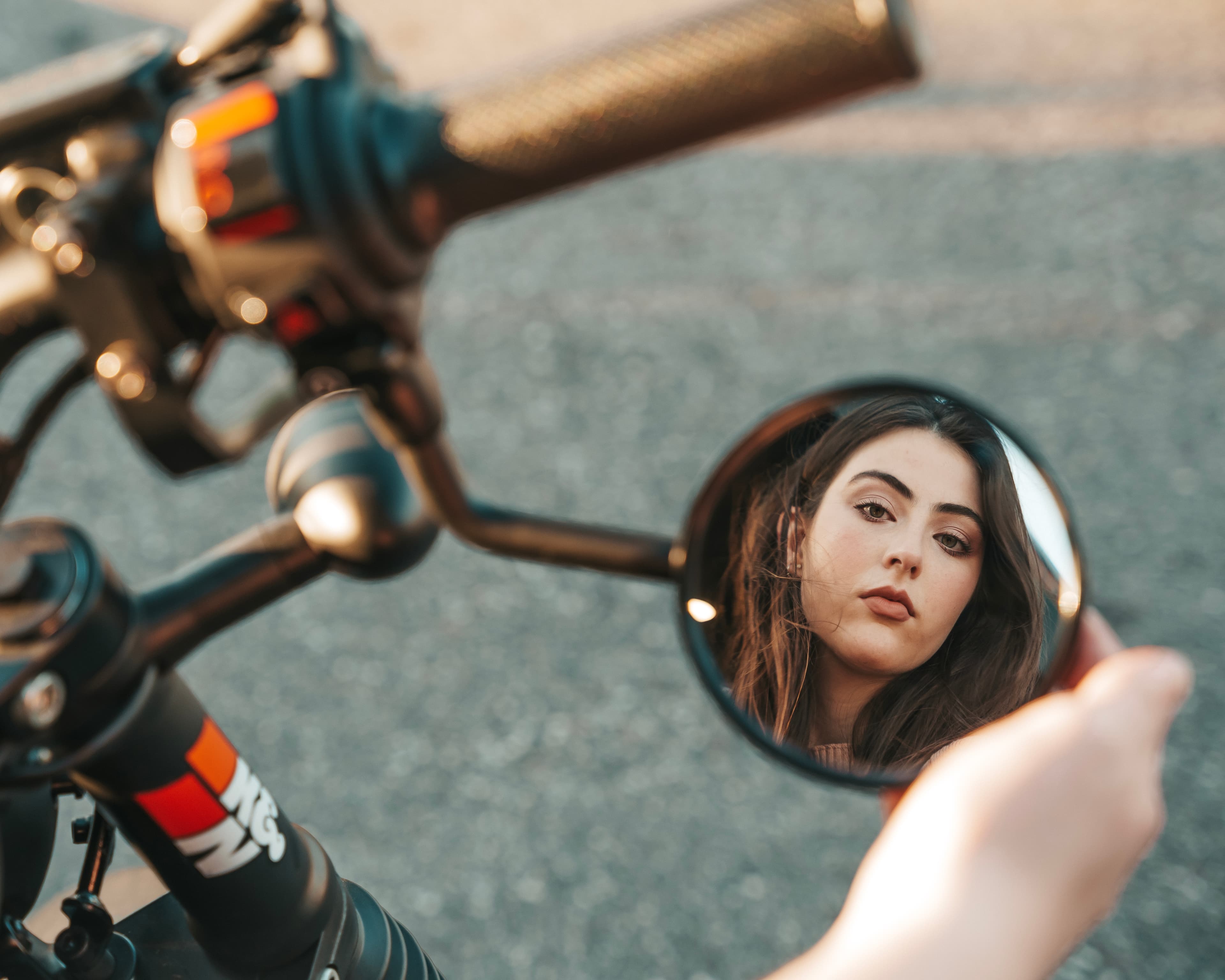 Woman reflected in motorcycle mirror