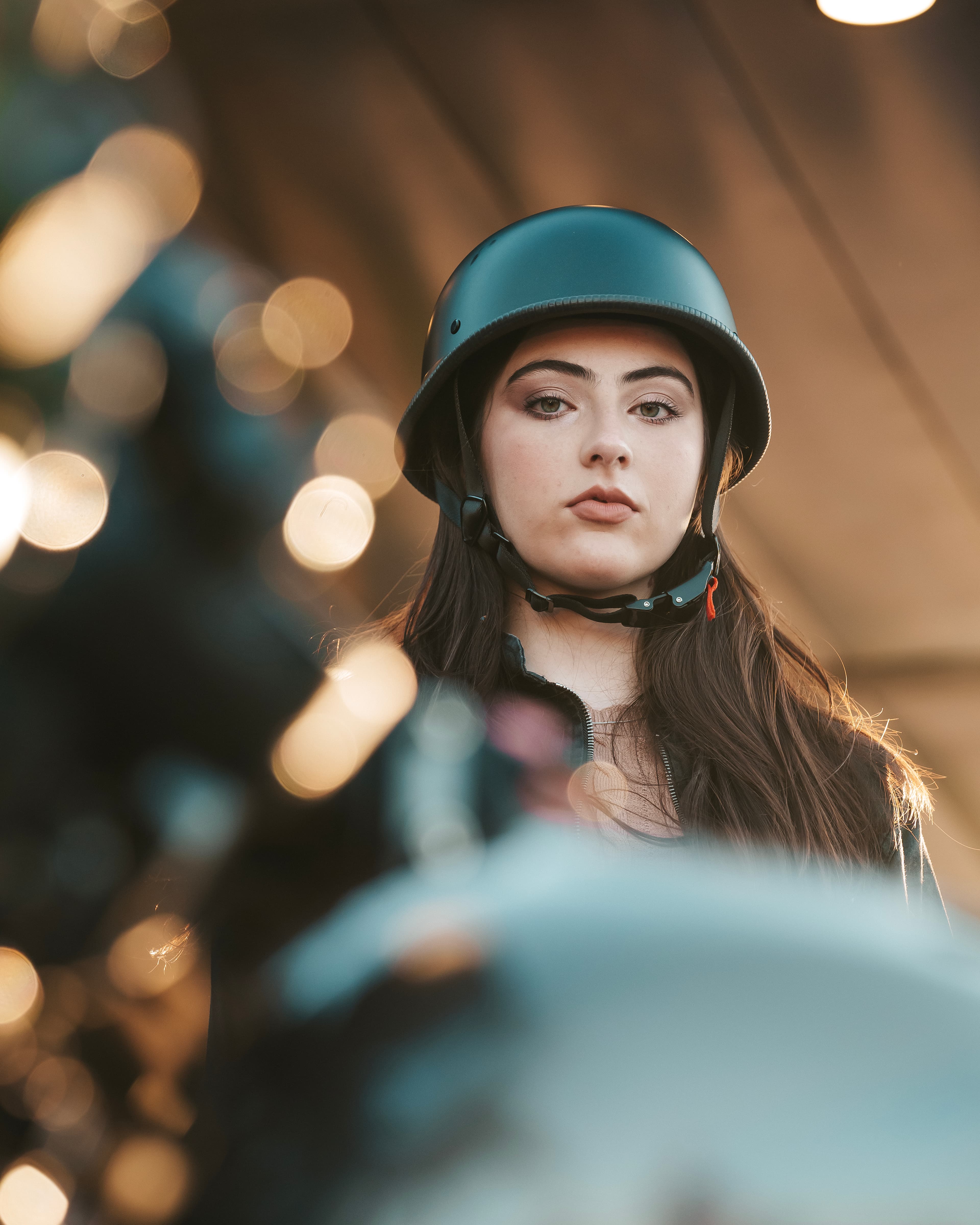Woman in motorcycle helmet, bokeh lights